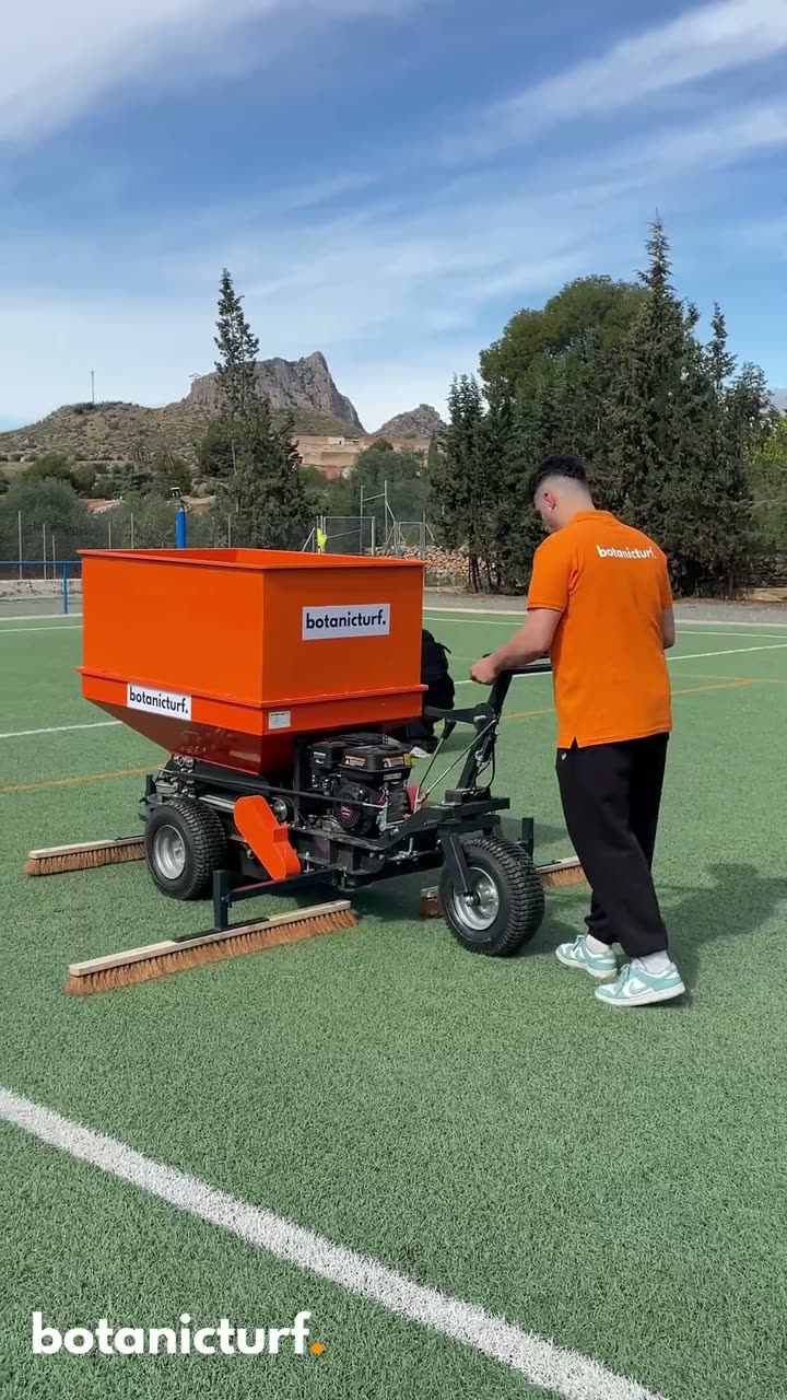 Operario con la máquina de distribución de botanicturf. sobre el campo