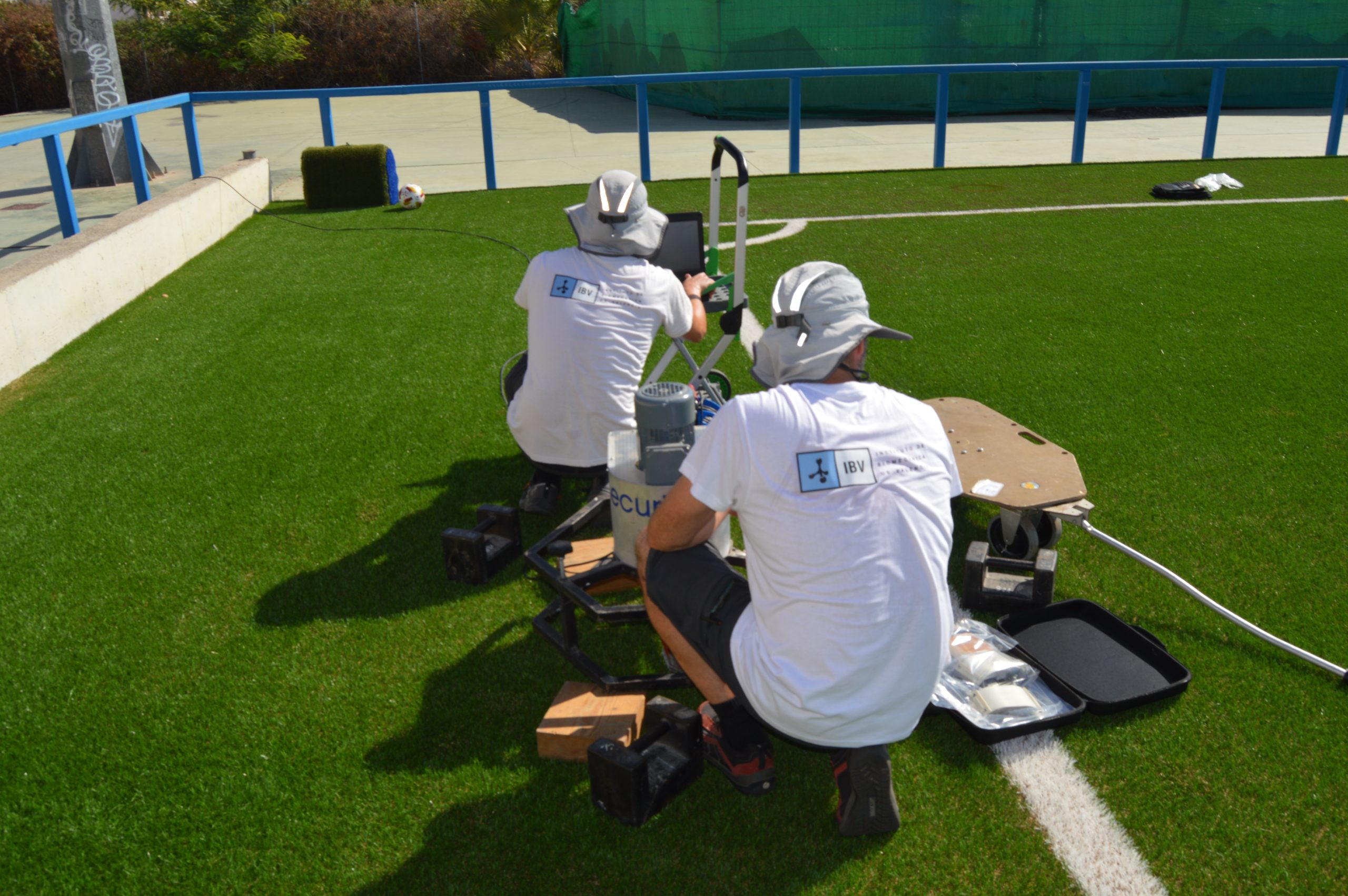 Técnicos realizando ensayos sobre un campo de césped artificial